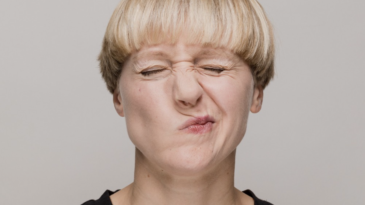Person with eyes closed scrunching up nose