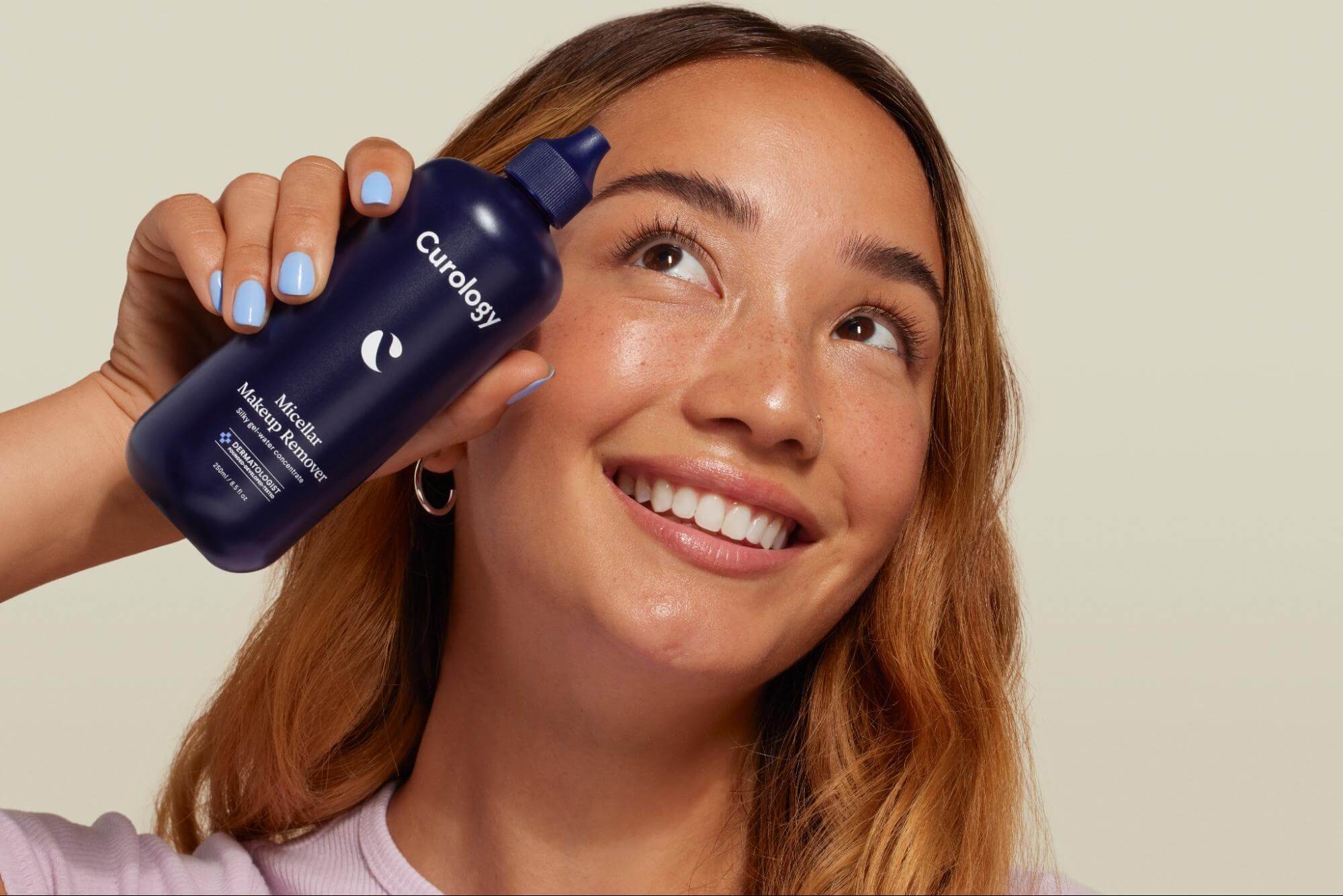 Woman holding up Curology's Micellar Makeup Remover