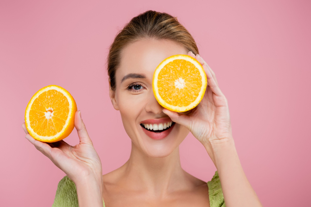 Woman holding oranges in front of eyes