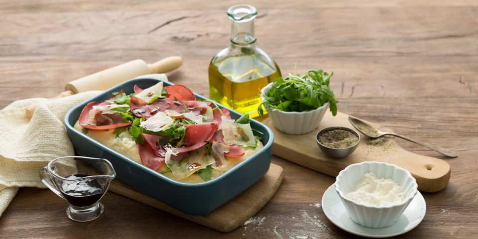Pizza mit Parmaschinken und Rucola Salat
