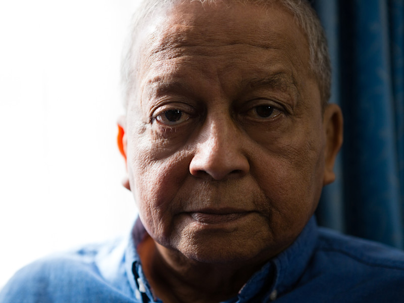 An older man looks directly into the camera. He looks worried.