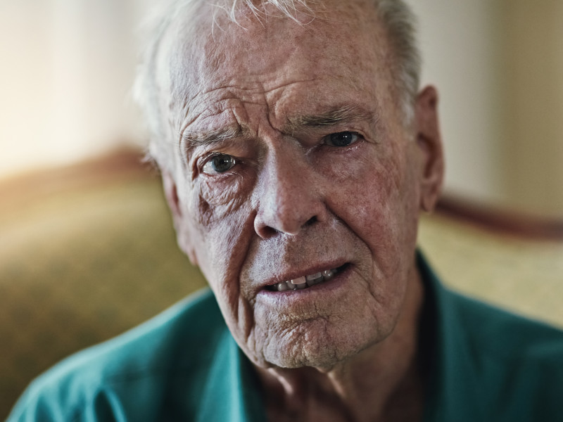 A close up of an older man looking directly into the camera. He looks upset.