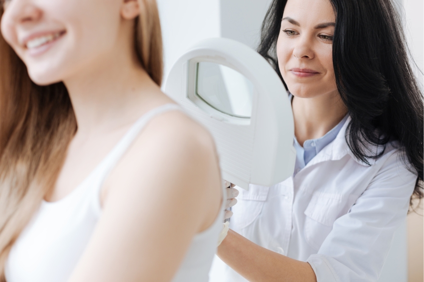 Dermatologist looking at a woman's back