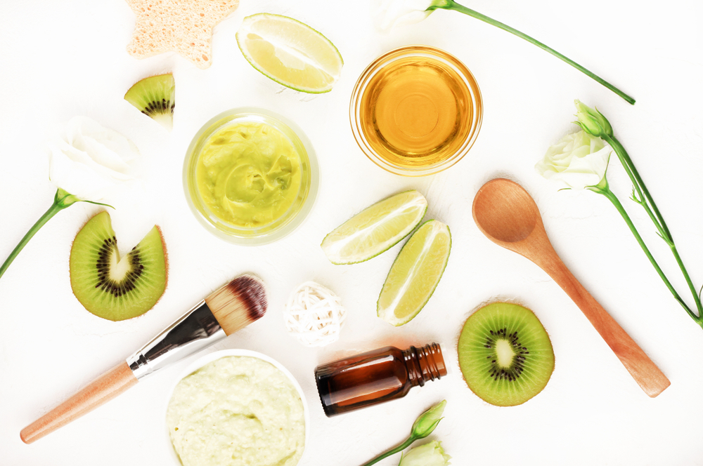 A display of natural skincare ingredients and application tools lie on a white background.