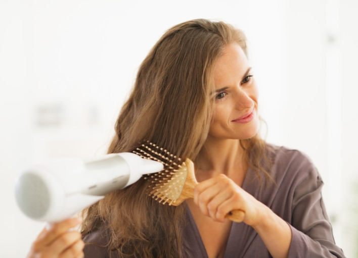 Woman drying hair in the bathroom