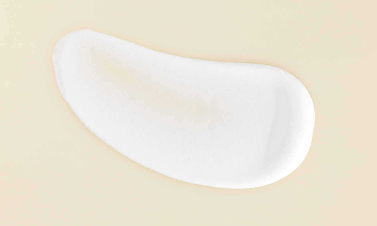 A delicate white cream positioned on a white surface showcasing its soft texture and uniform color