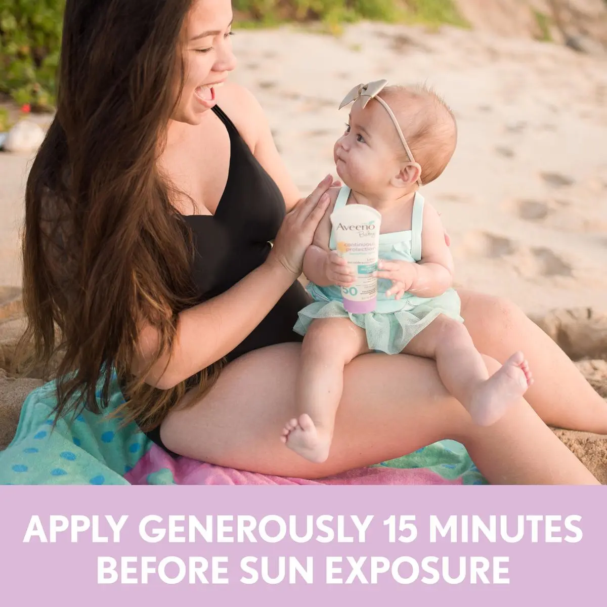 Woman applying Aveeno® sunscreen on her baby and text apply sunscreen 15 minutes before sun exposure