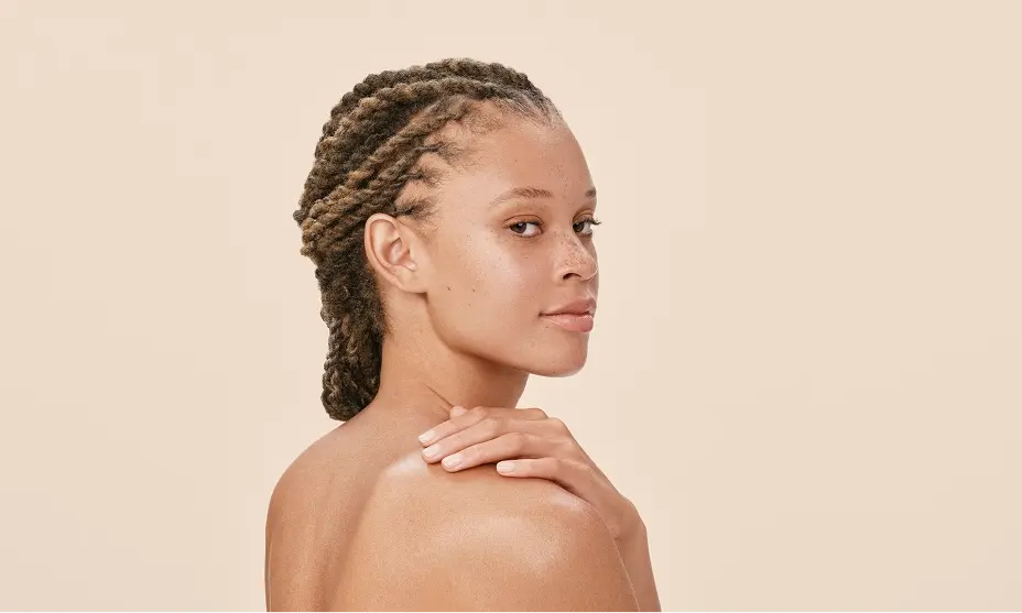 Woman gently resting her hand on her shoulder, promoting skin relief and comfort.