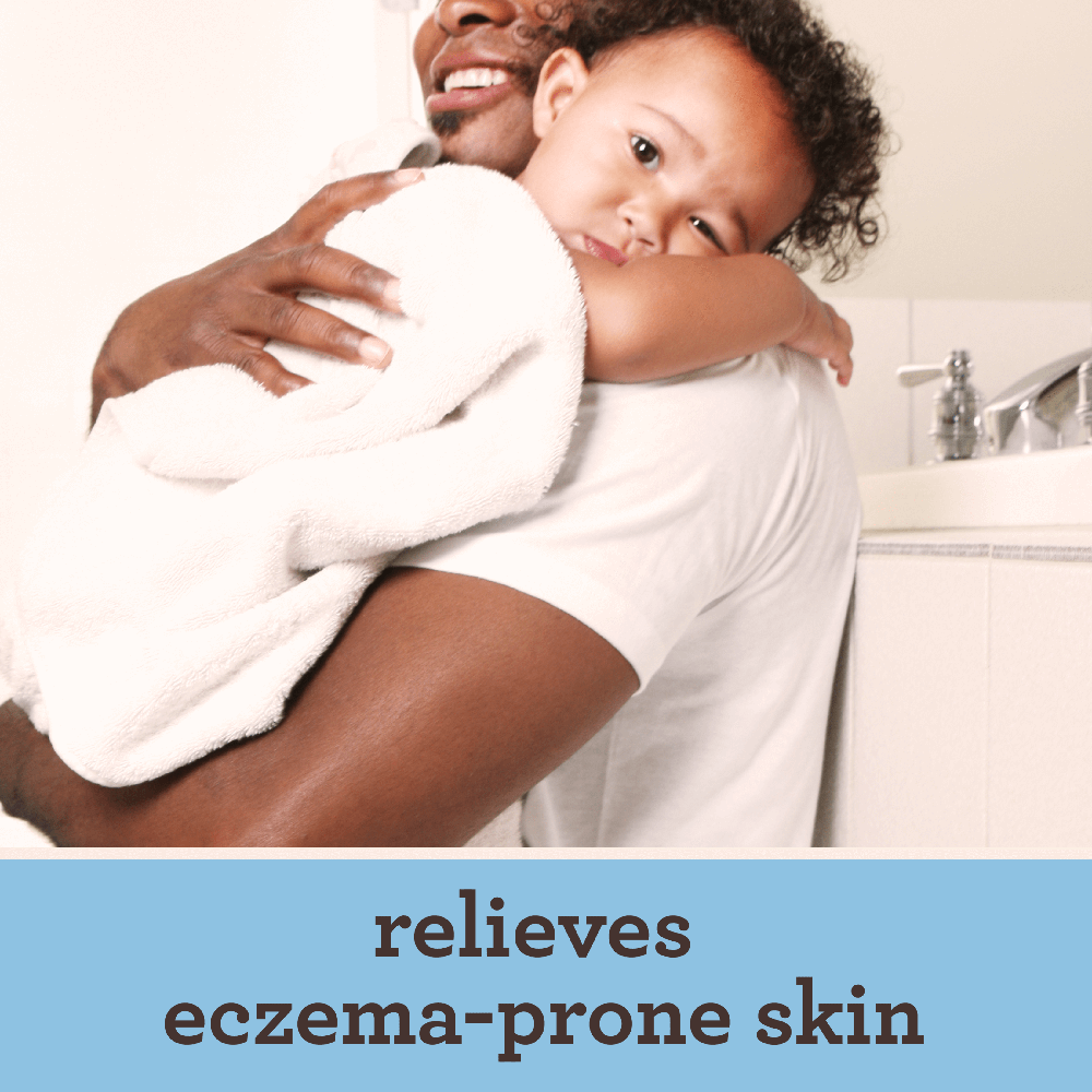 Man gently holds a baby in a bathroom showcasing a tender moment of care and connection between them