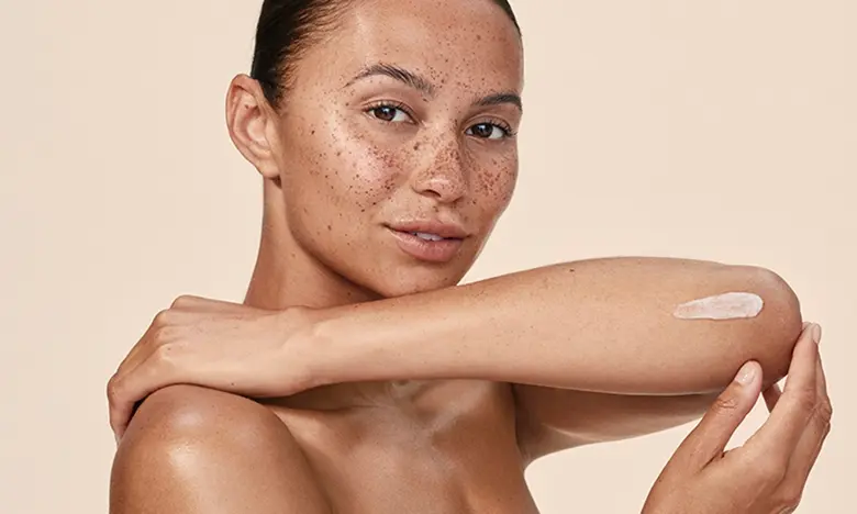 Sensitive Skin: Your Daily Care banner, image of a woman applying cream to her arms.