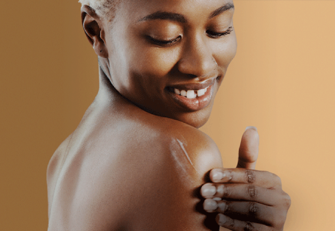 Woman applying lotion to uneven skin tone