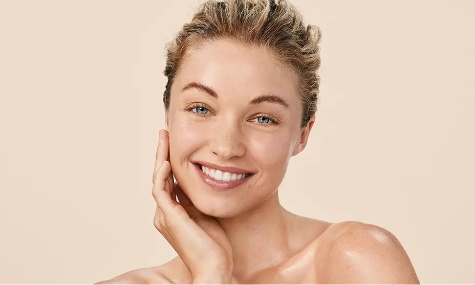 Happy woman with Aveeno Calm + Restore skincare for sensitive skin.