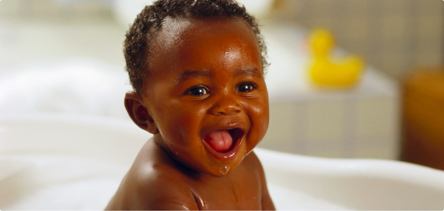 smiling baby sitting in bath