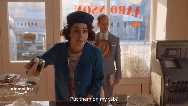 A GIF from ‘The Marvelous Mrs. Maisel’ in which Midge grabs a half-moon cookie and says, “Put them on my tab?”