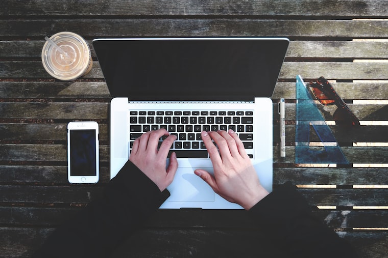 Photo of someone typing on a laptop, by Stanley Dai