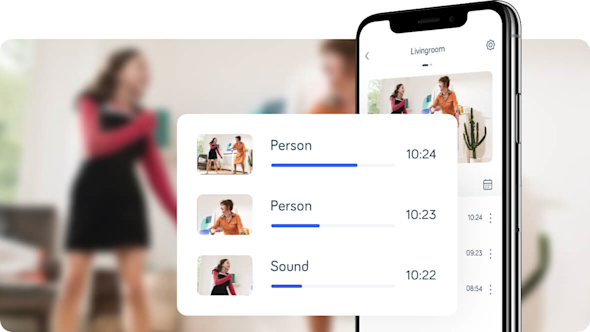 Smartphone with screen pop-out showing Hive app recording from the Hive Indoor Camera, with a girl and an older woman dancing in a blurred background.