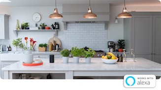 Bright kitchen with marble top kitchen island, white tiles on the wall in the background and three large copper lampshades hanging from the ceiling