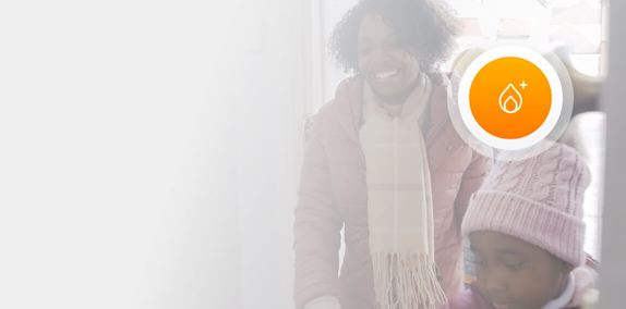 Mother and daughter dressed in winter clothes and walking into their home with an orange icon superimposed over the top right corner
