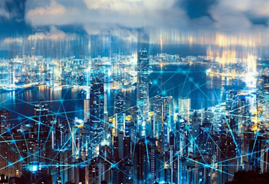 A city at night overlooking a river with bright blue lines connecting between buildings