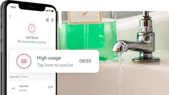 Side angle of a smartphone showing the Hive app with a pop-out screen showing a Hive leak alert message, with a chrome tape running water in the background