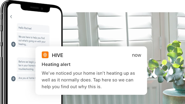 Side angle of smartphone showing Hive app with a pop-out screen in the middle of the image showing Hive heating alert, with white shutter blinds and a green plant in the background image
