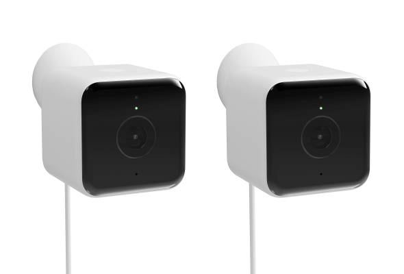 Side angle view of two Hive Outdoor Cameras, with white wires hanging from the bottom, on a white background