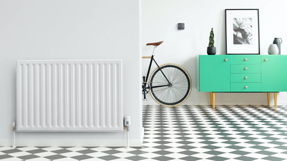 Large hallway with black and white floor tiles, a radiator in the foreground wall with a Hive Radiator Valve attached, a green drawer unit in the background next to a Hive Thermostat on the wall and a bike propped up against the wall