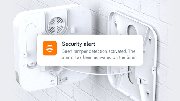 Hive Siren attached to a white brick wall but broken in two with a security screen alert superimposed over the top