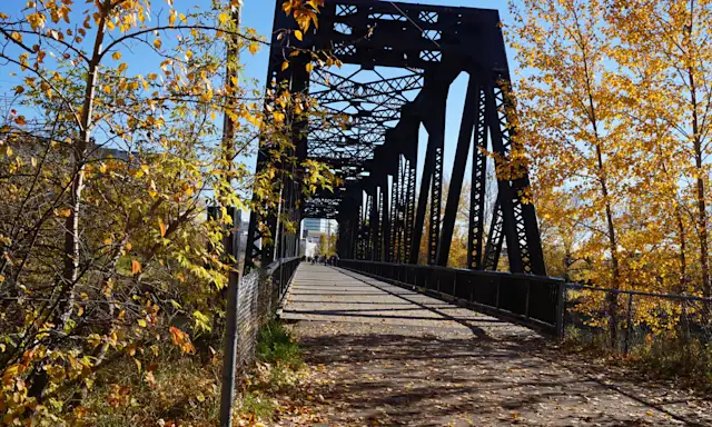 Old metal bridge surrounded by autumn trees in Red Deer, Alberta