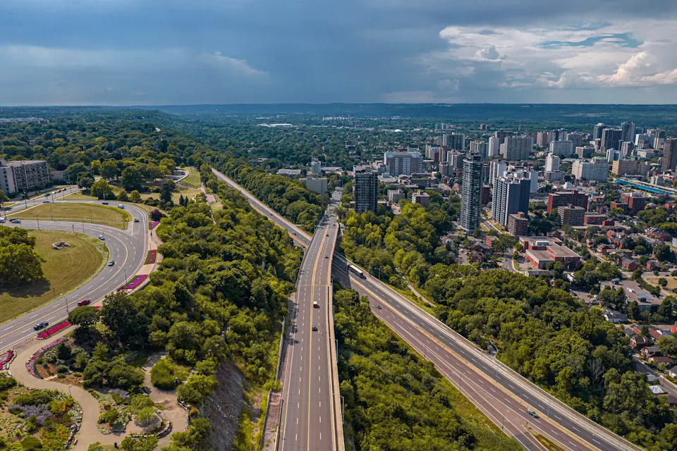Aerial view of Hamilton, Ontario, showing the city's skyline, highways, and surrounding greenery.