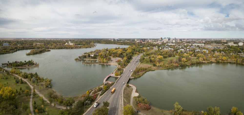 Aerial view of Regina with roads, lakes, and surrounding greenery.