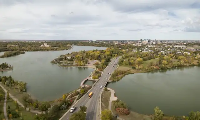Aerial view of Regina with roads, lakes, and surrounding greenery.