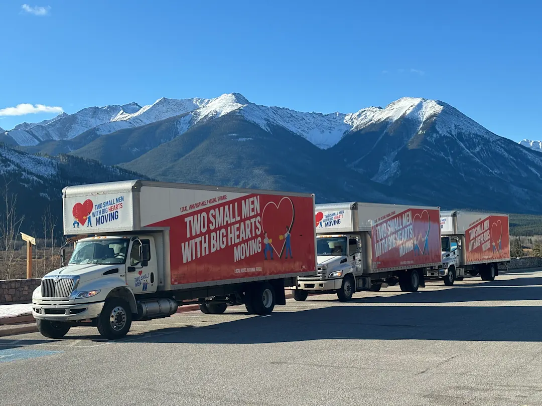 3 Two Small Men with Big Hearts Moving Vans in a row as they travel through the mountains.