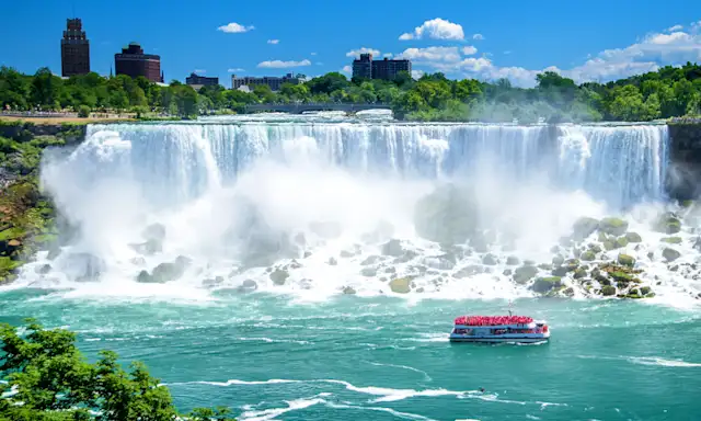 Boat approaching the American Falls at Niagara Falls on a sunny day.