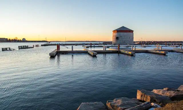 Kingston Ontario waterfront at sunset with historic Martello tower and docks