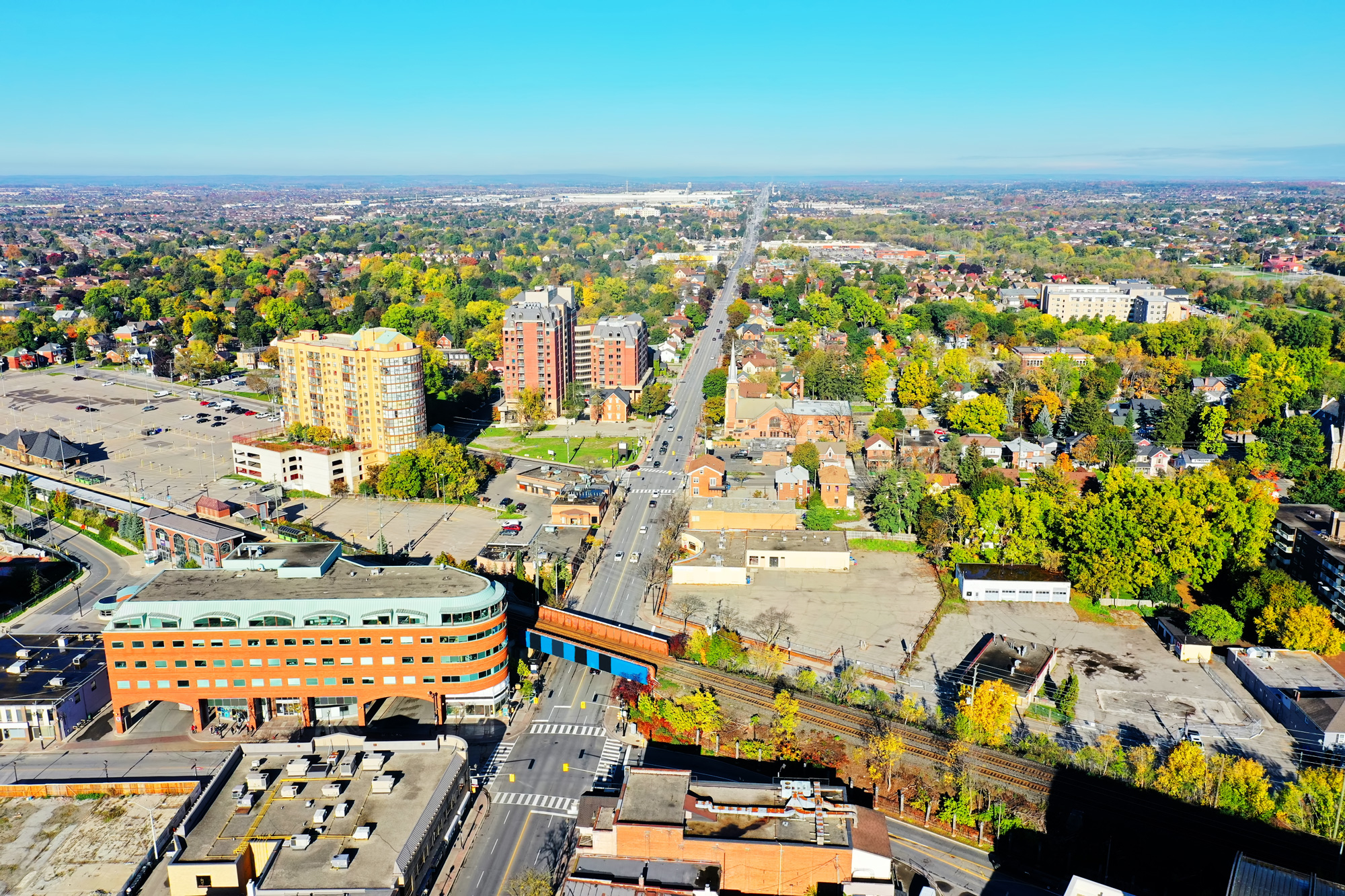 Aerial view of Brampton, showing streets, buildings, and green spaces extending into the distance.