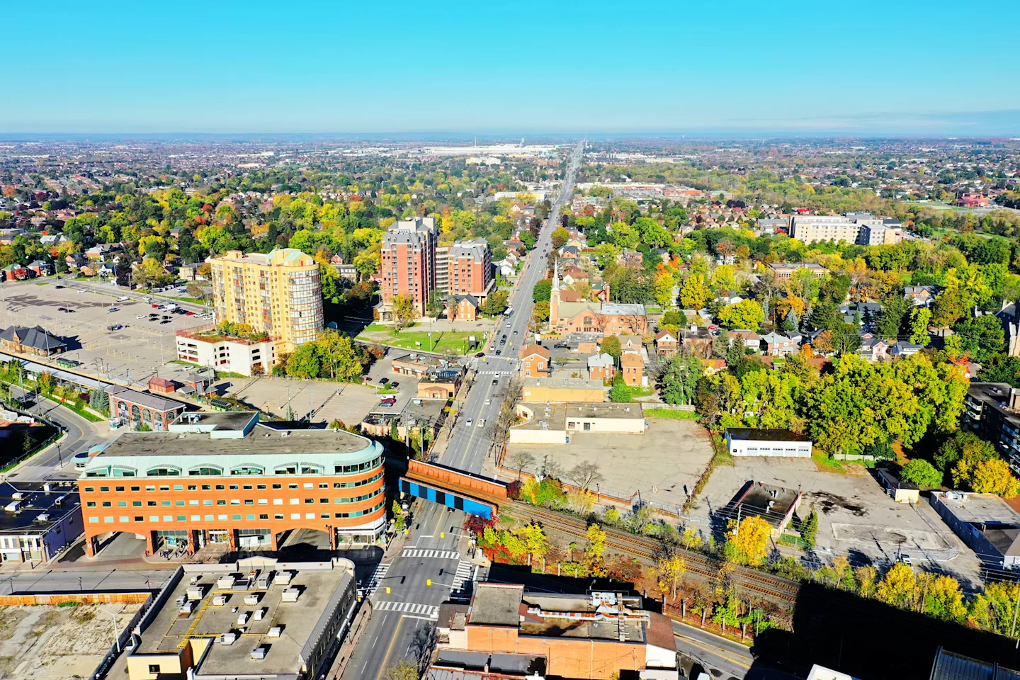 Aerial view of Brampton, showing streets, buildings, and green spaces extending into the distance.