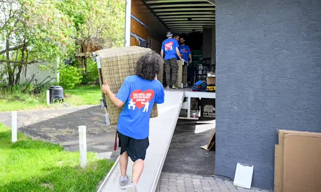 Movers in Two Small Men with Big Hearts Moving shirts loading a truck with furniture