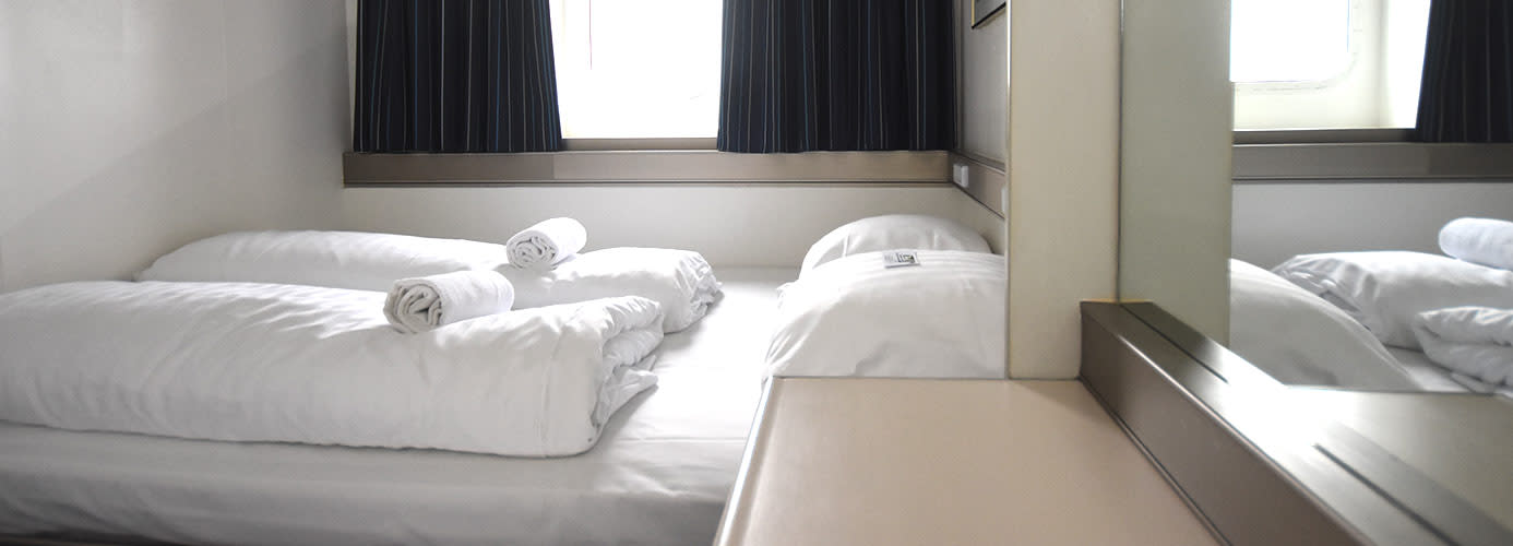 Łóżko dwuosobowe i okno w kabinie na promie