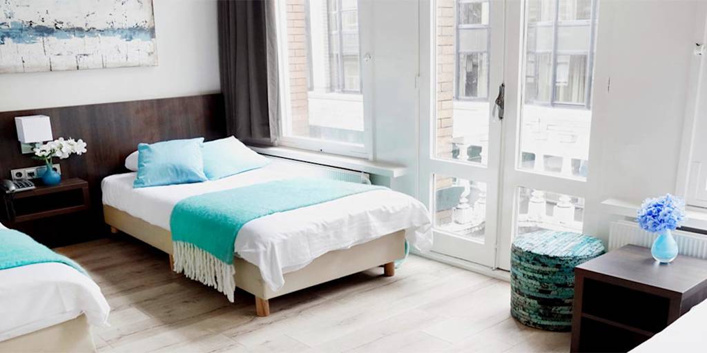 A comfortable hotel room with a double bed De-Gerstekorrel-Hotel