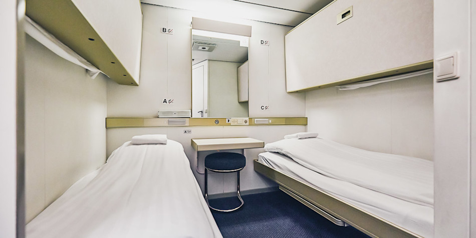 Two freshly made single beds in an economy cabin 