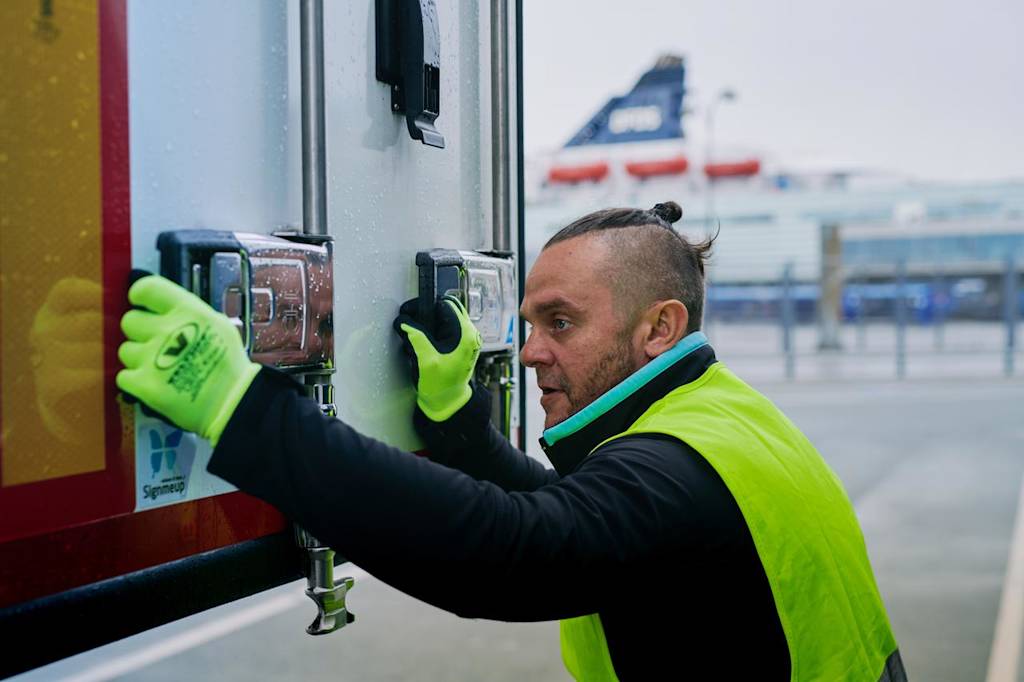A DFDS worker locking up a reefer with cold goods. Cold chain worker locking up a reefer