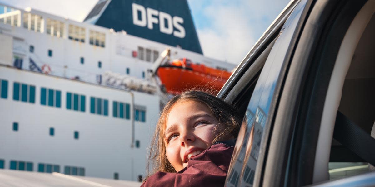 Excited little girl leaning out a car's window, with in the background a DFDS passenger vessel DOT.PRJCT DFDS Photography Campaign-15 - About index page, link box PAX
