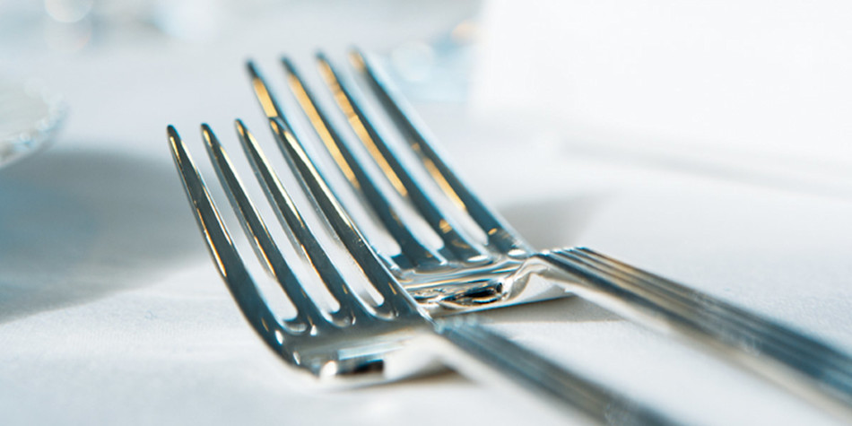 Two silver forks that have been laid out on the restaurant table