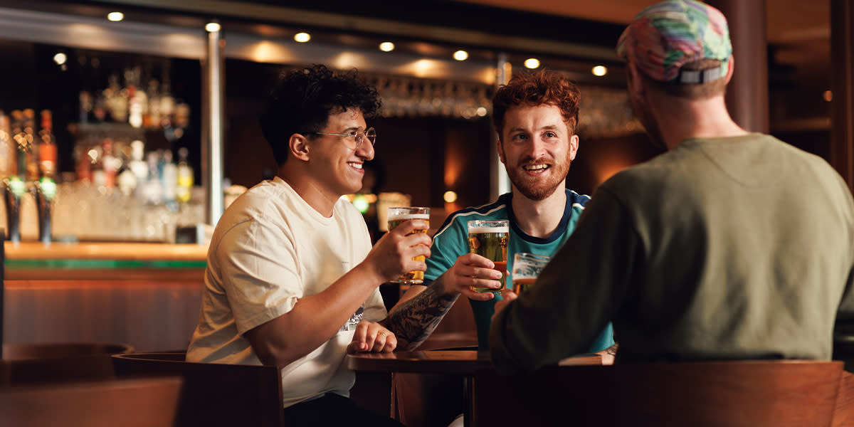 Drei Freunde trinken zusammen Bier in einer Bar