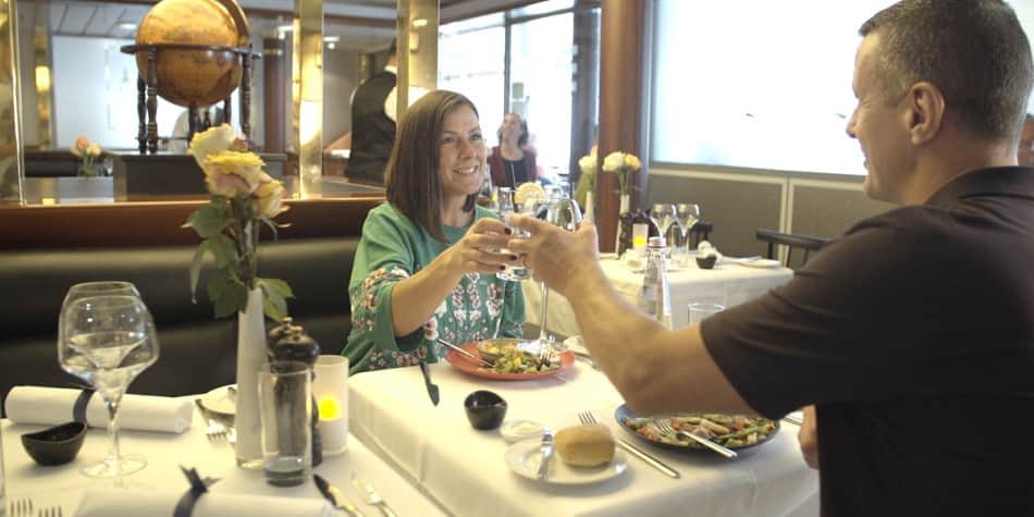 Paar sitzt im Restaurant und stößt mit Weißwein an