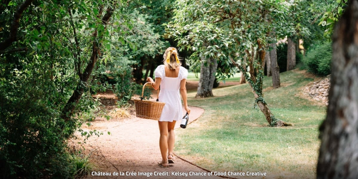 Lady walking with basket at Château de la Crée