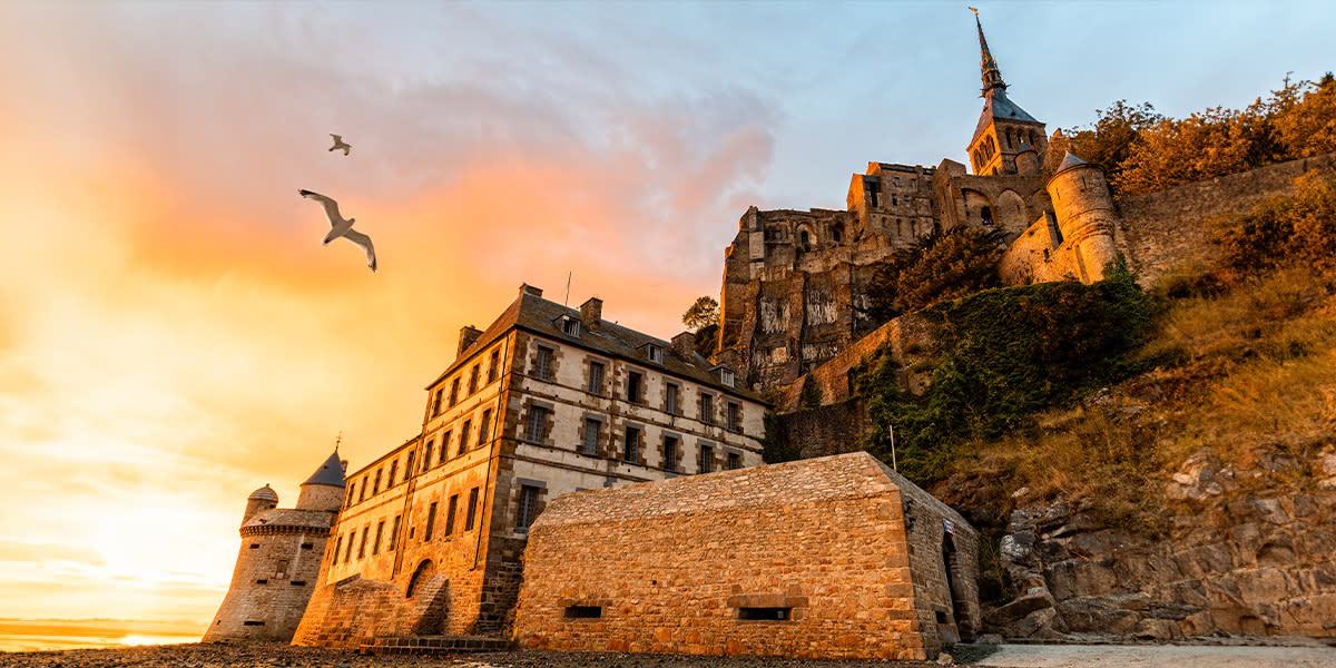 Mont Saint-Michel at sunset with seagulls