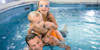 A family playing together in one of the swimming pools. 