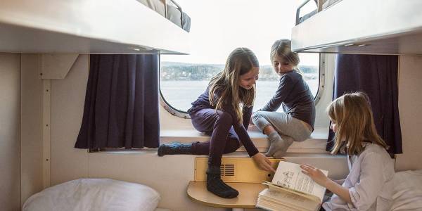 Børn hygger om bord i kahyt med vindue - familie